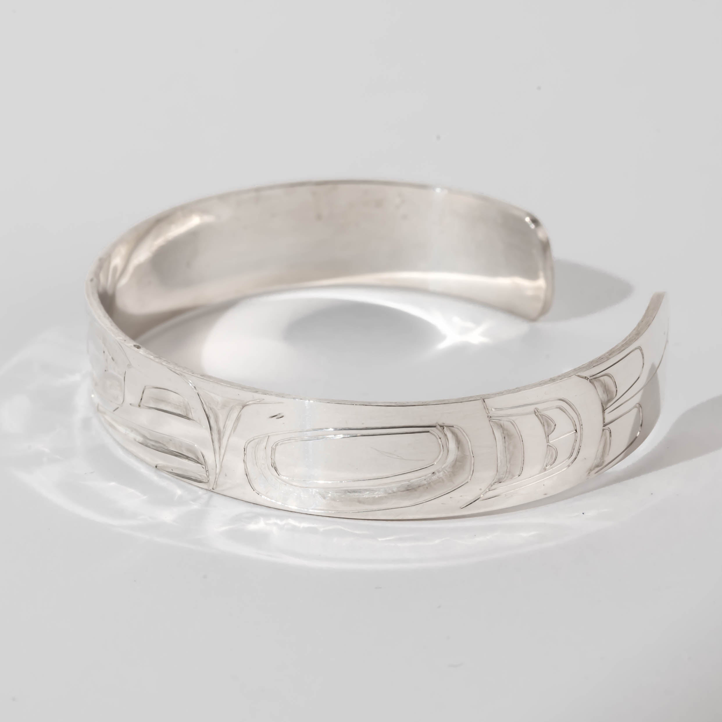 Hand carved sterling silver Eagle bracelet by Haida artist Alvin Adkins side view