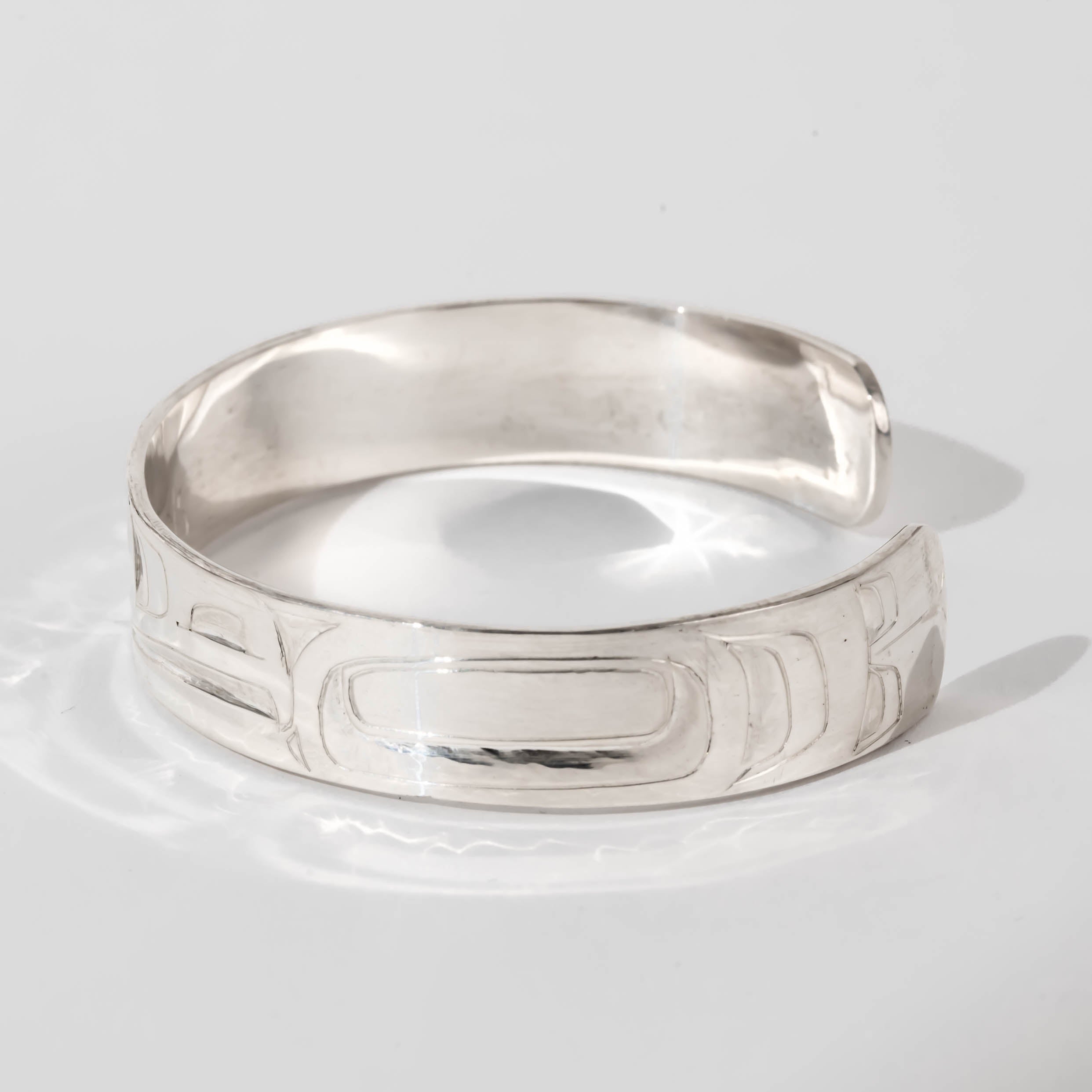 Hand carved sterling silver Raven bracelet by Haida artist Alvin Adkins side view
