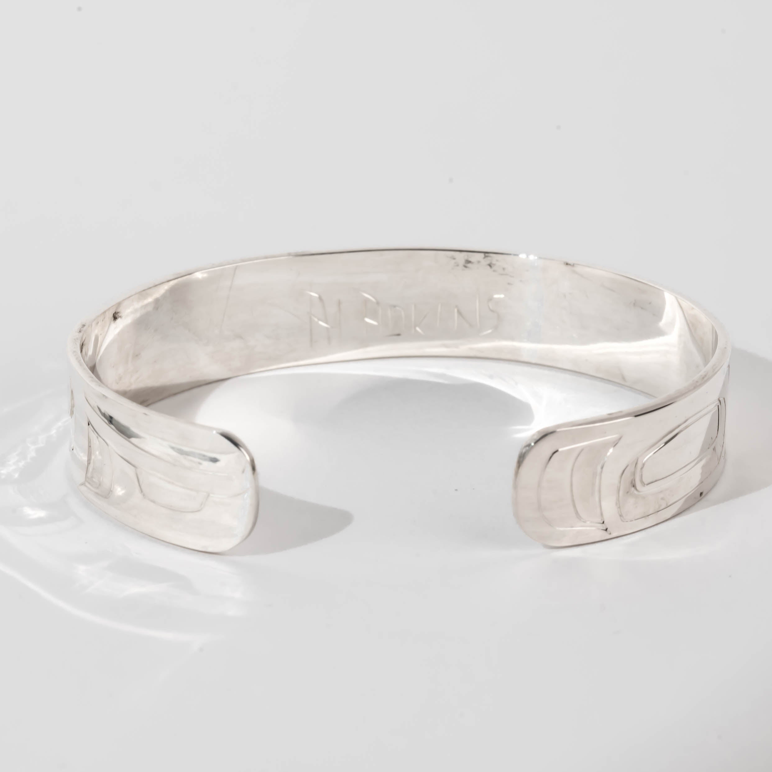 Hand carved sterling silver Orca bracelet by Haida artist Alvin Adkins side view