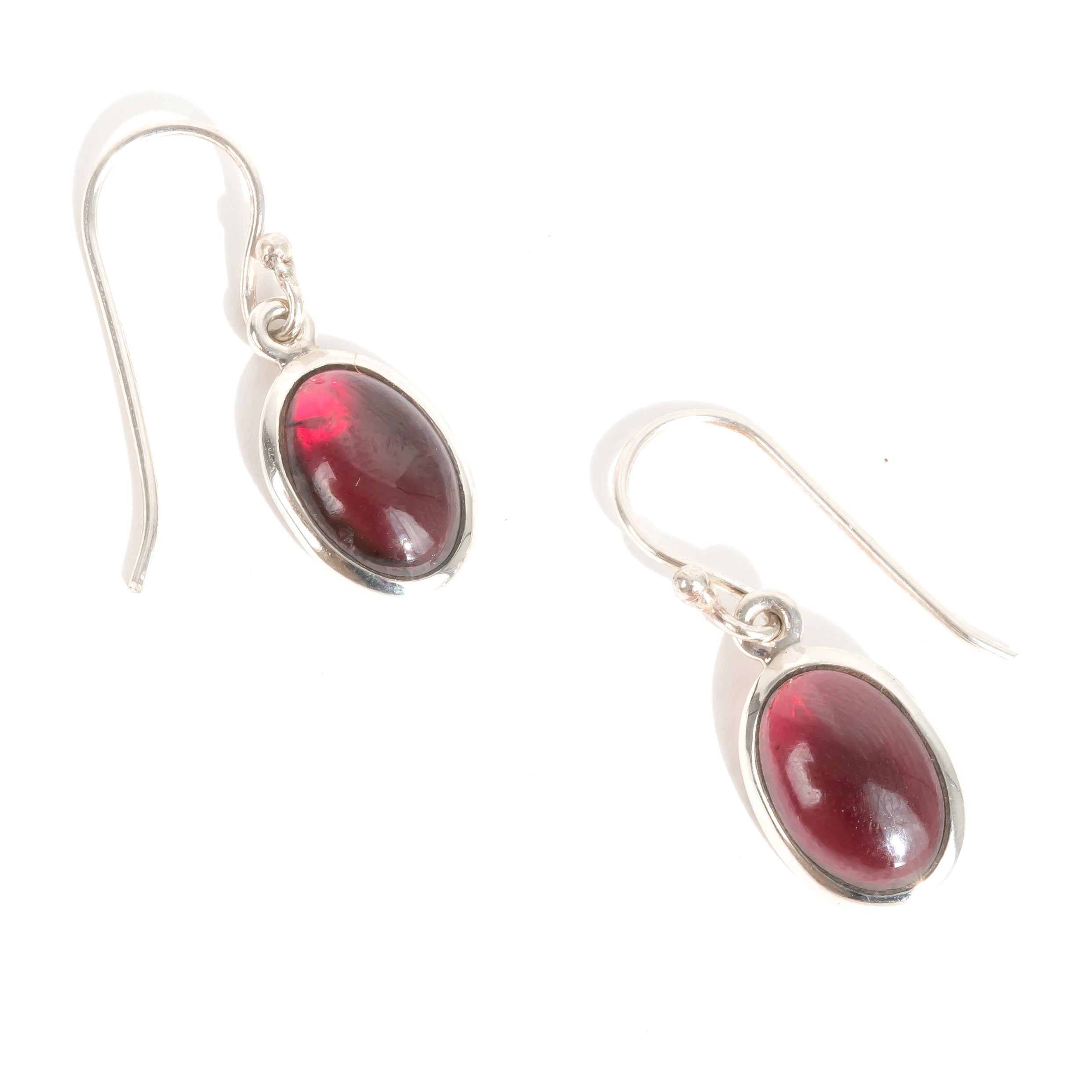 Silver earrings with red garnet gemstones for January's birthstone on a white background