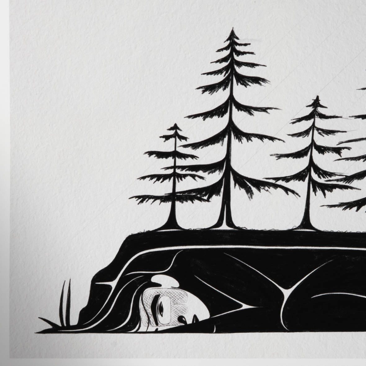 Close-up left corner of a black and white art print of a woman's face, arm, body, and trees growing overhead.