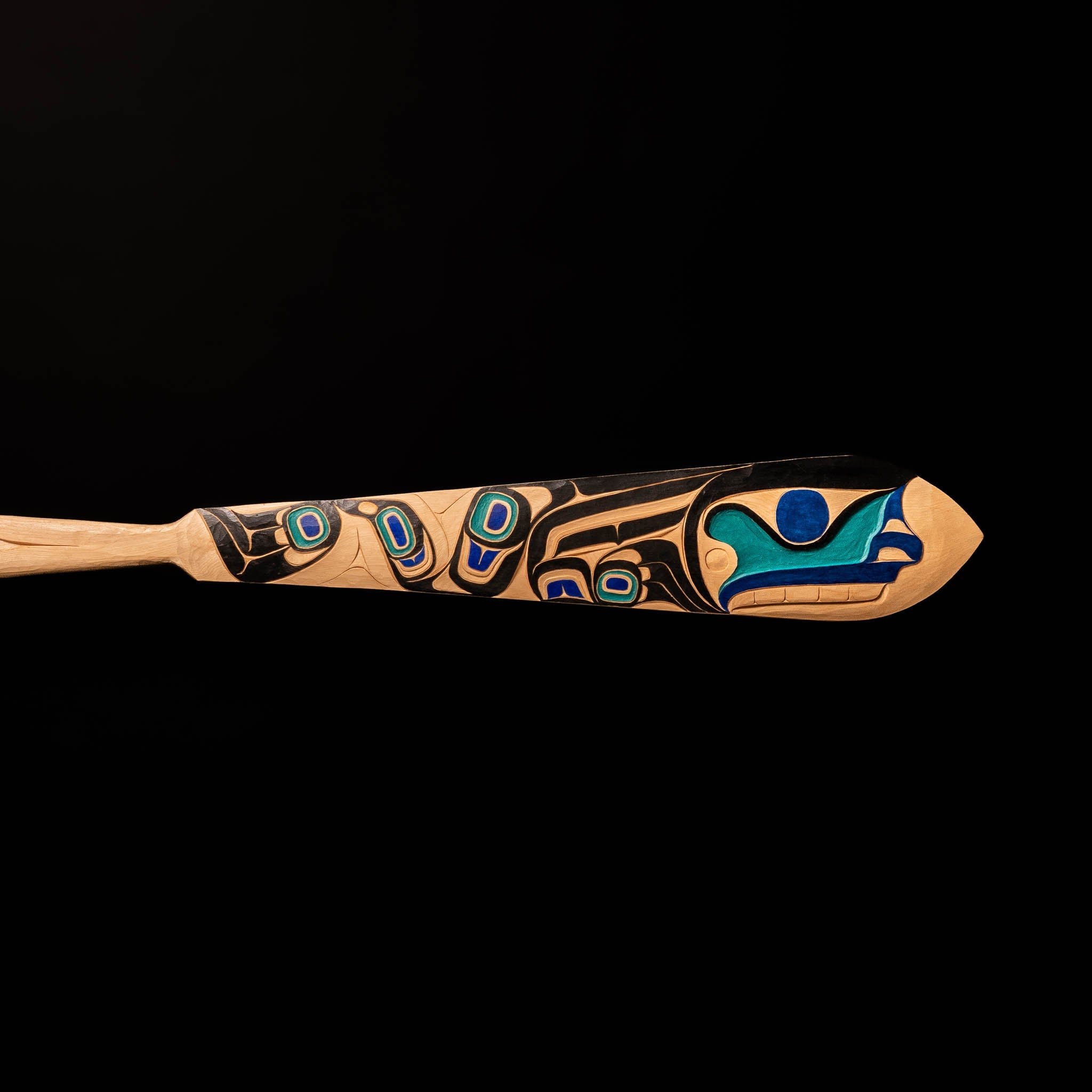 Tip of 'The Wayfinder' Haida Paddle Art by Billy Yovanovich on lack background.