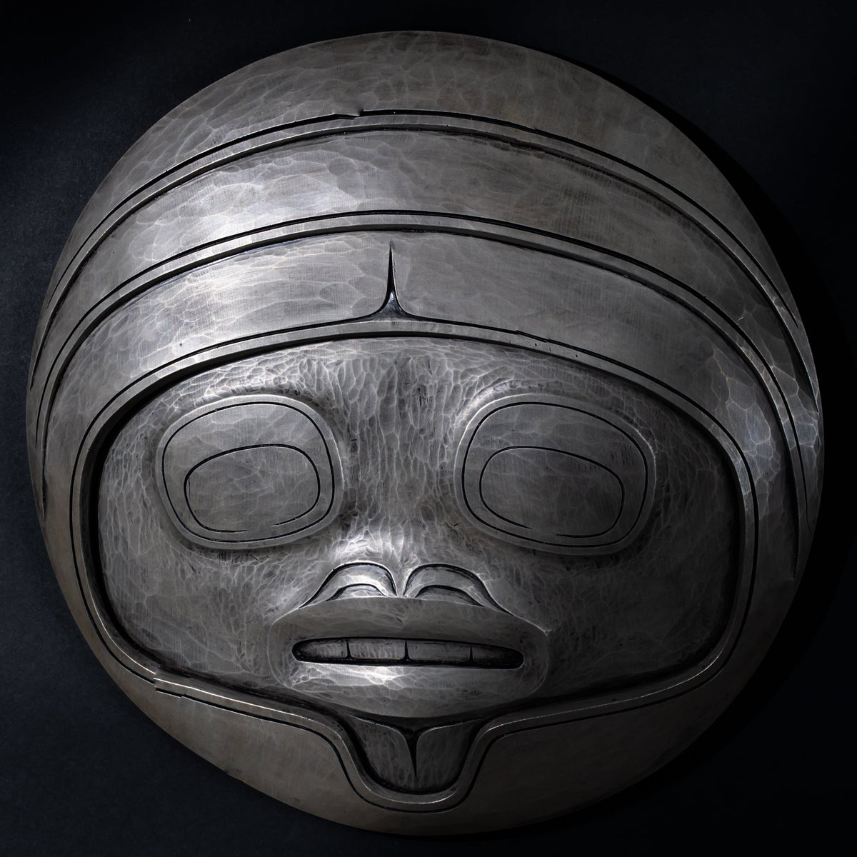 Fungus man mask casting with intricate carvings by Cori Savard on a dark wooden background