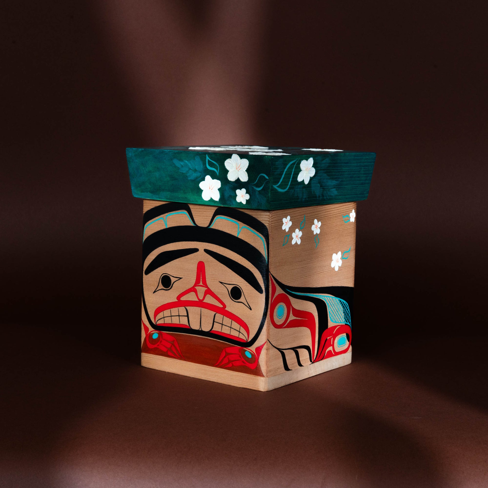 Decorative Haida Bentwood box with artistic formline design on a dark background