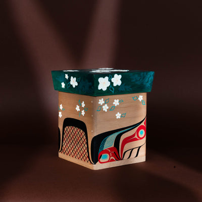Decorative Haida bentwood box with floral and abstract formline beaver designs on a brown background