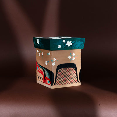 Decorative Haida Bentwood box with floral patterns and a colorful formline Beaver design on a brown background