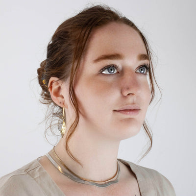 Woman wearing 18K gold mouse woman earrings by Morgan Asoyuf