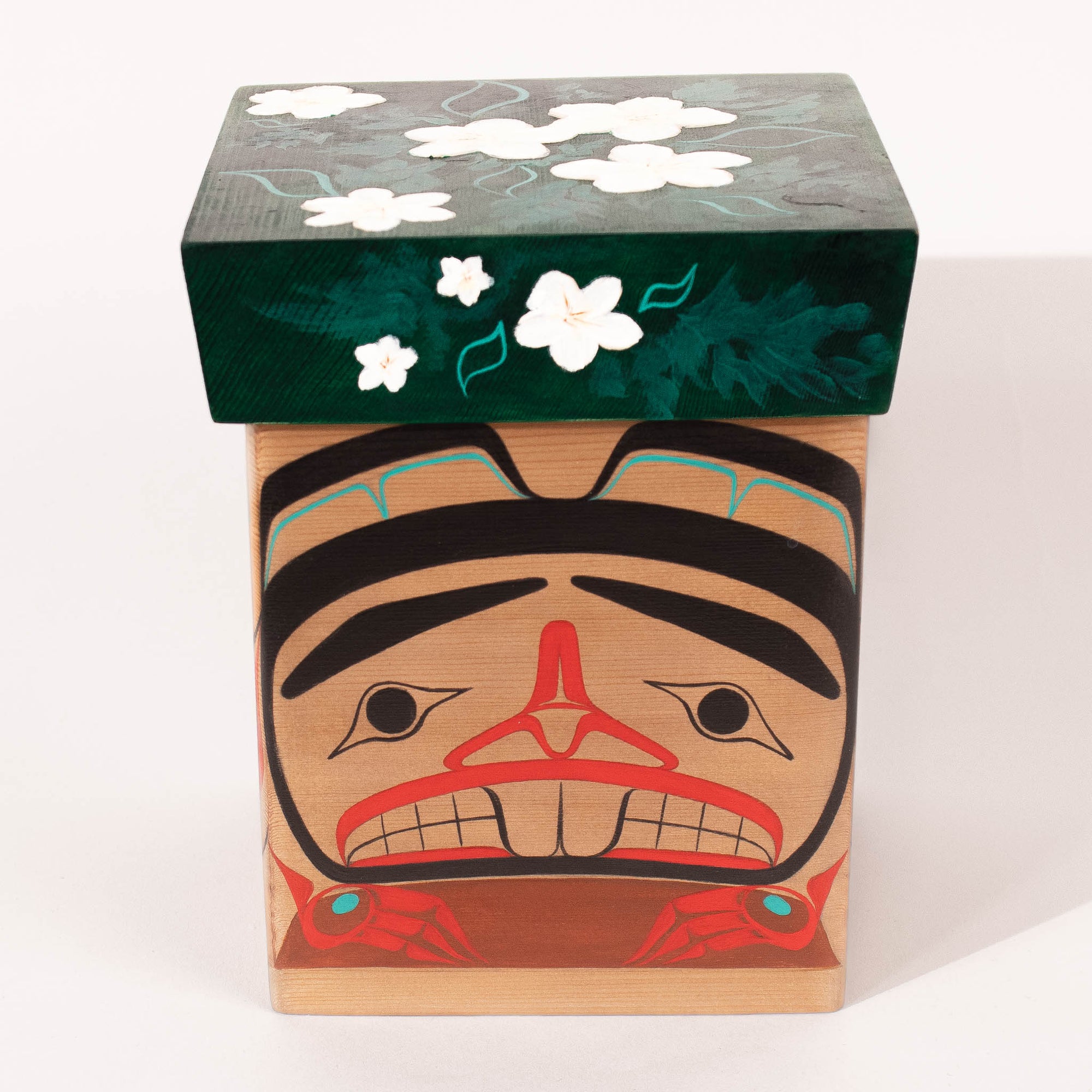 Wooden box with a face design and floral top on a white background