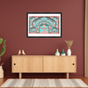 Framed abstract artwork on a red wall above a wooden cabinet with decorative items.