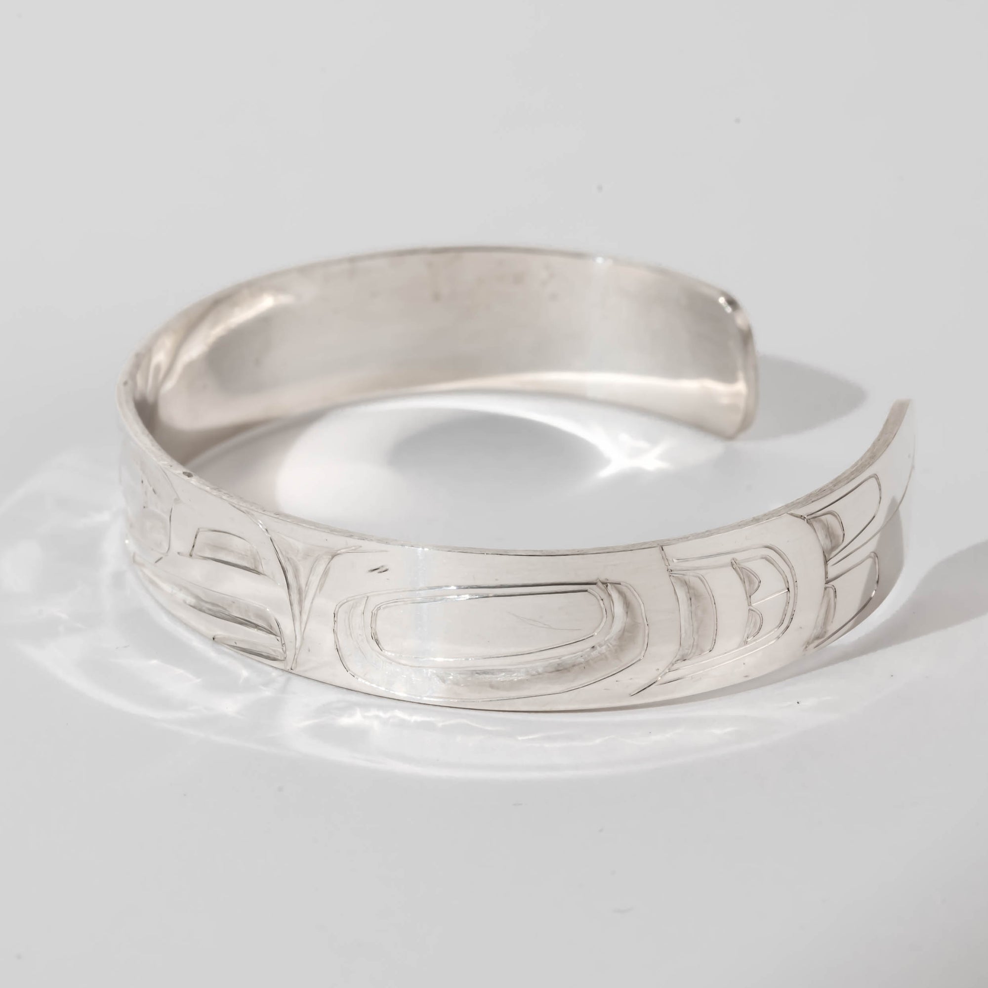 Hand carved sterling silver Eagle bracelet by Haida artist Alvin Adkins side view