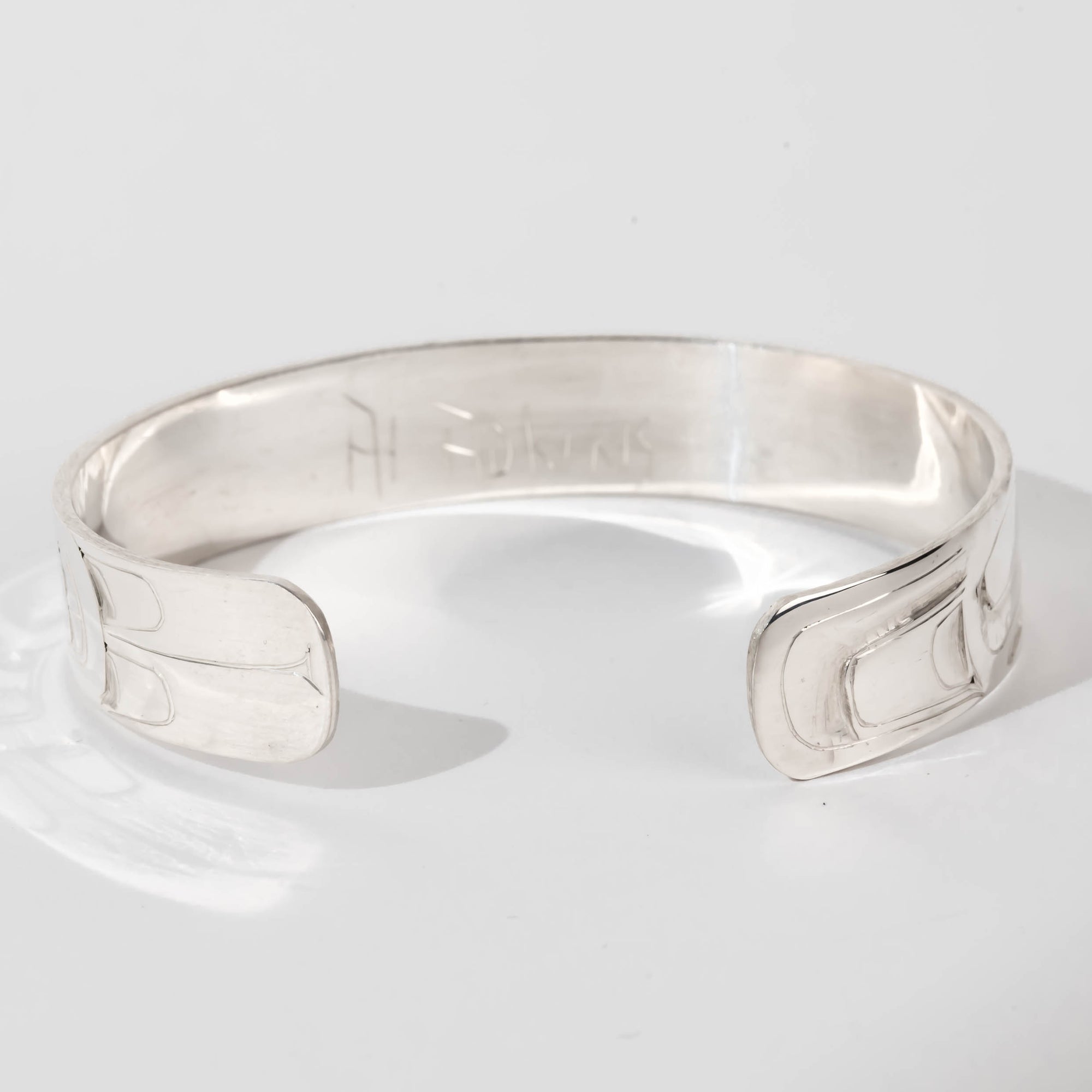 Hand carved sterling silver Eagle bracelet by Haida artist Alvin Adkins back view with original signature