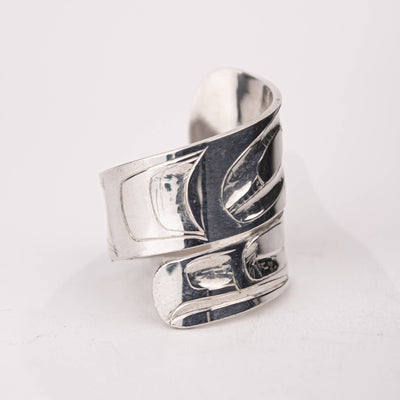 Silver ring with intricate design on a white background