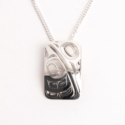 Silver hand carved hummingbird pendant necklace on a white background