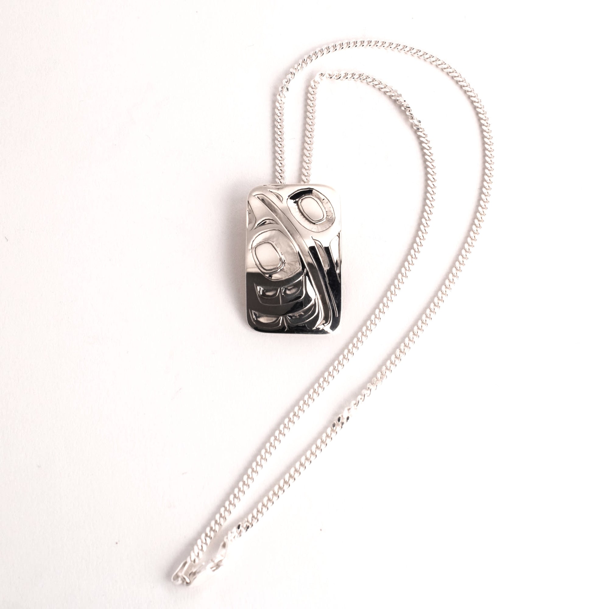 Silver necklace with a unique pendant on a white background
