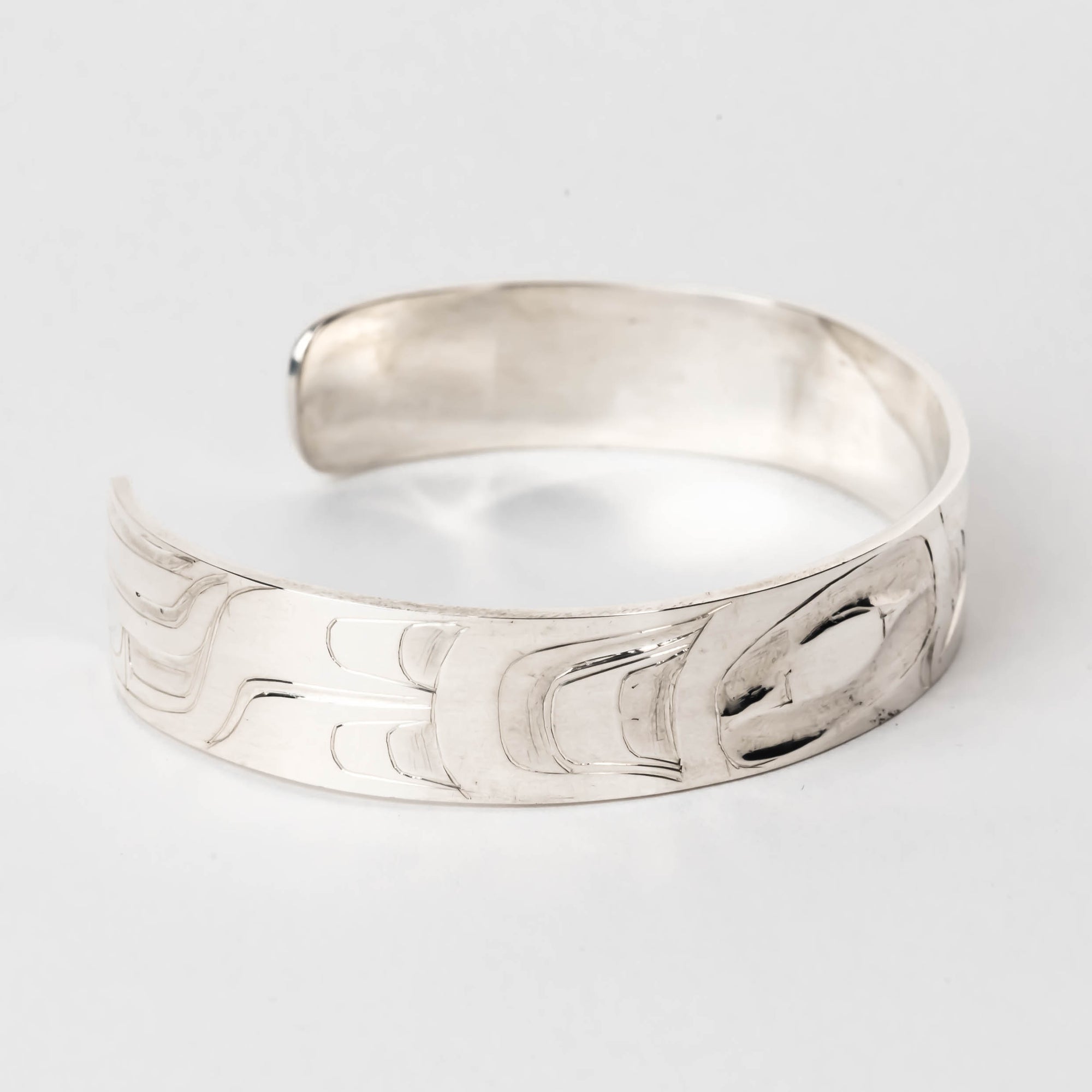 Hand carved sterling silver hummingbird bracelet by Haida artist Alvin Adkins side view