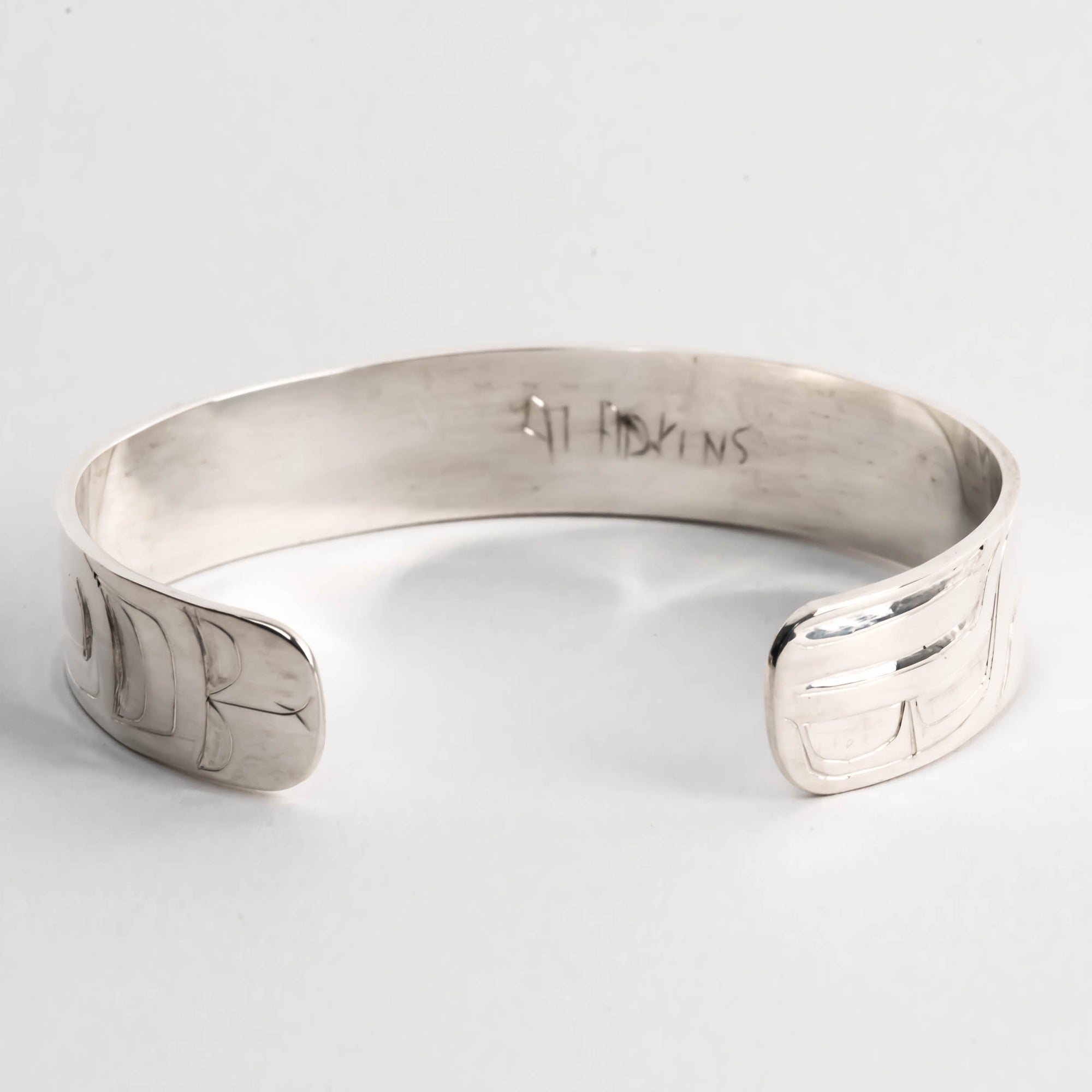 Hand carved sterling silver hummingbird bracelet by Haida artist Alvin Adkins back view of original signature