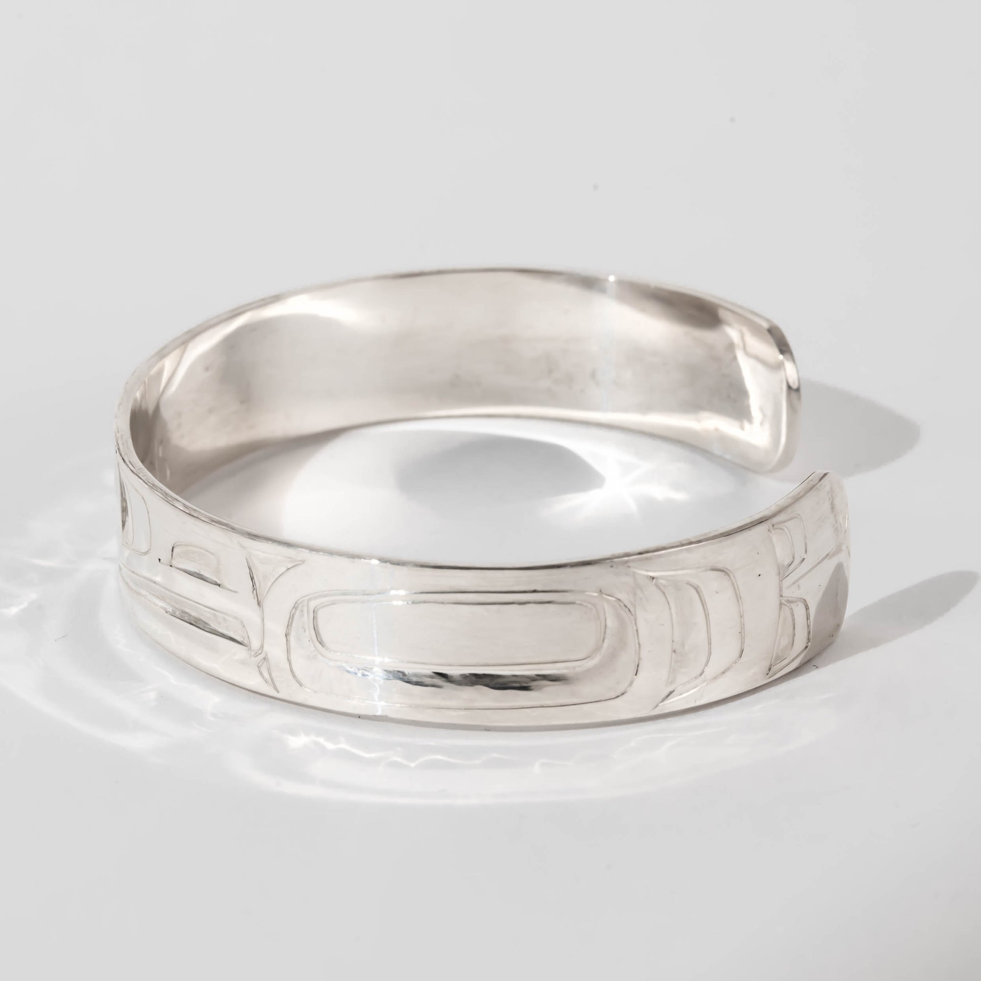 Hand carved sterling silver Raven bracelet by Haida artist Alvin Adkins side view