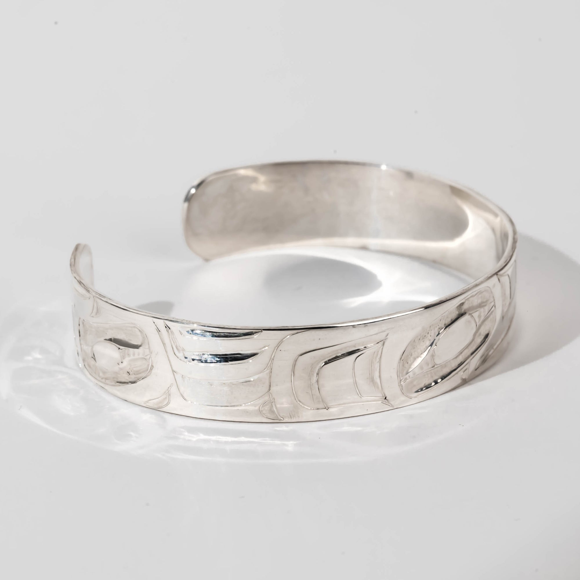 Hand carved sterling silver Raven bracelet by Haida artist Alvin Adkins side view