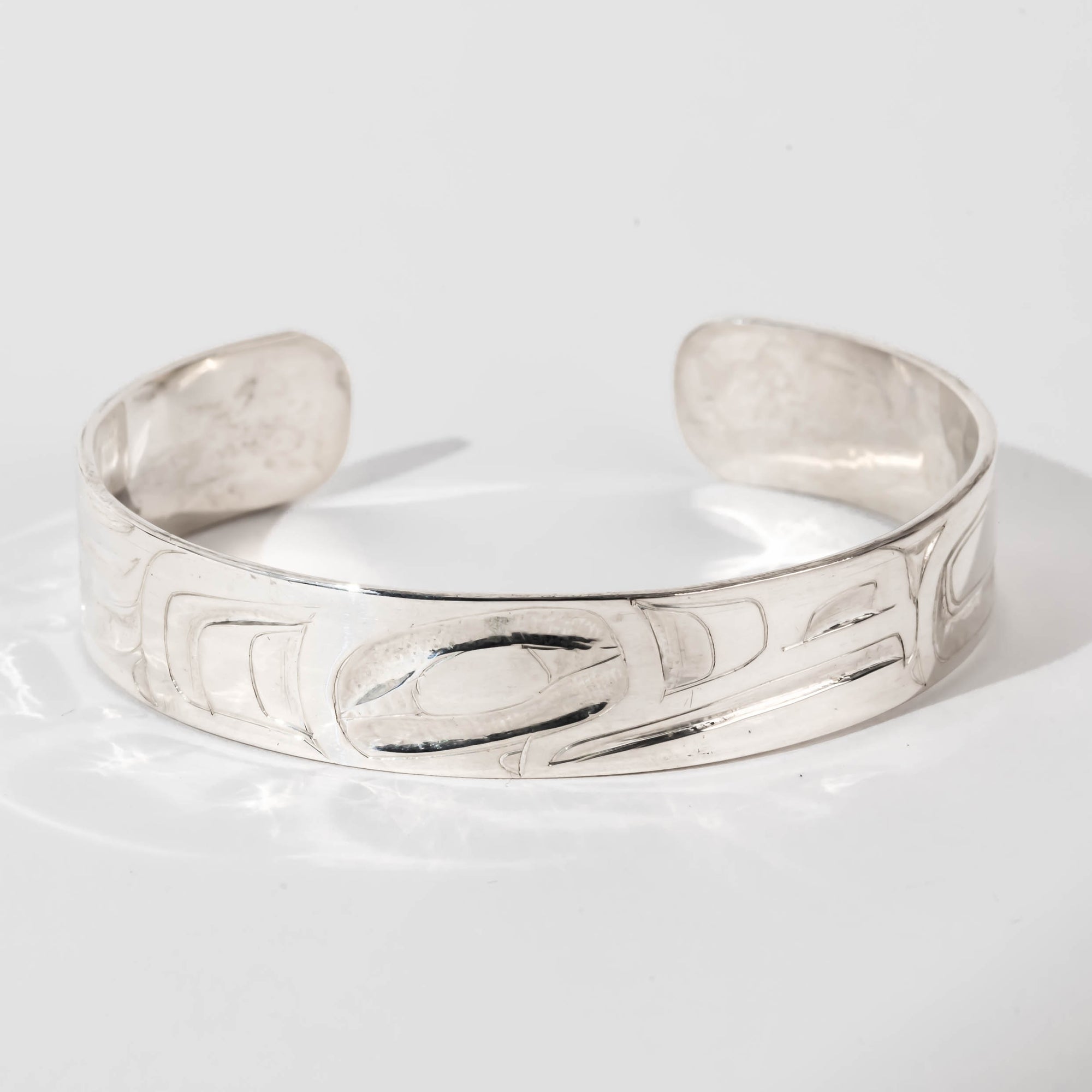 Hand carved sterling silver Raven bracelet by Haida artist Alvin Adkins front view