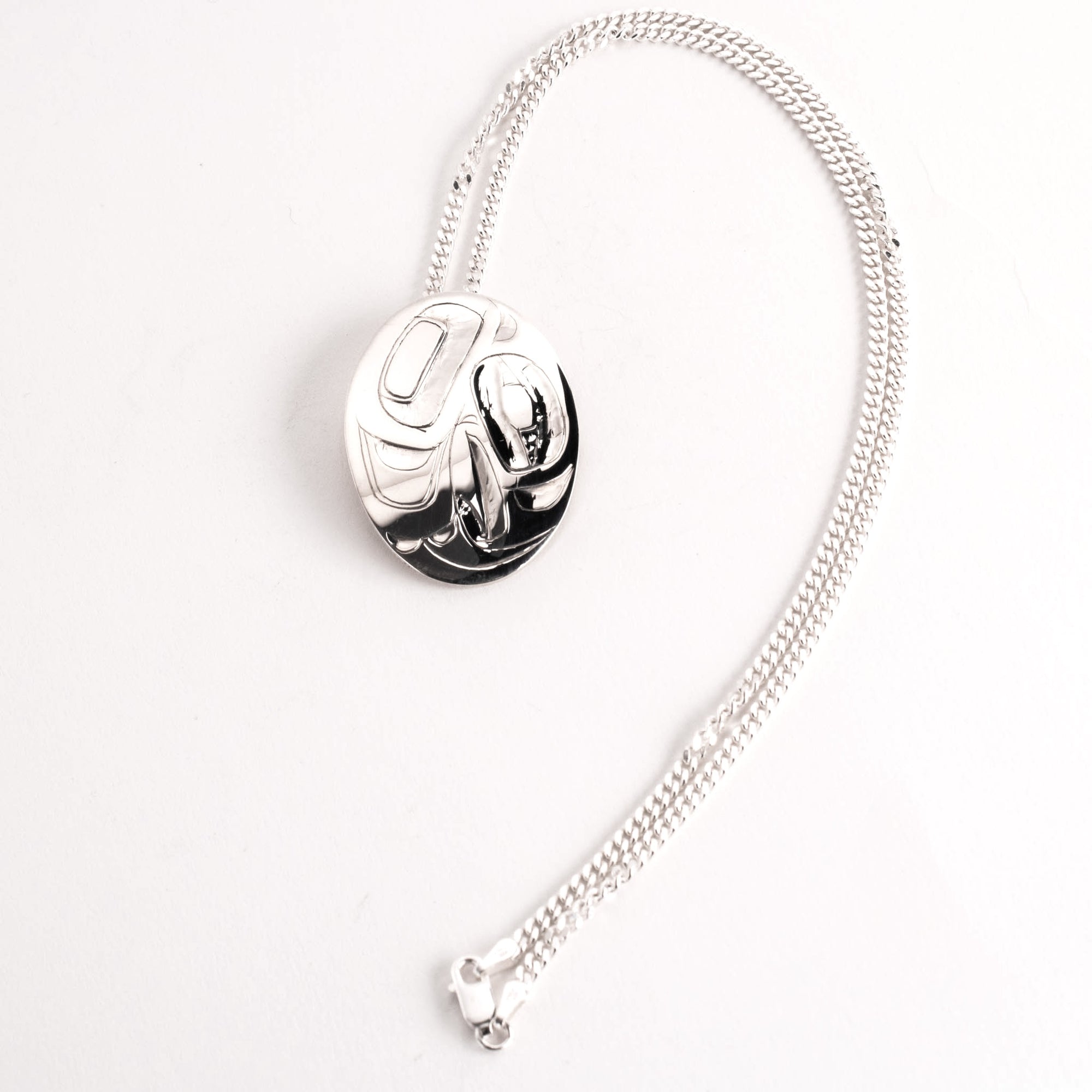 Silver necklace with a hand carved eagle pendant on a white background
