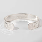 Hand carved sterling silver Orca bracelet by Haida artist Alvin Adkins side view