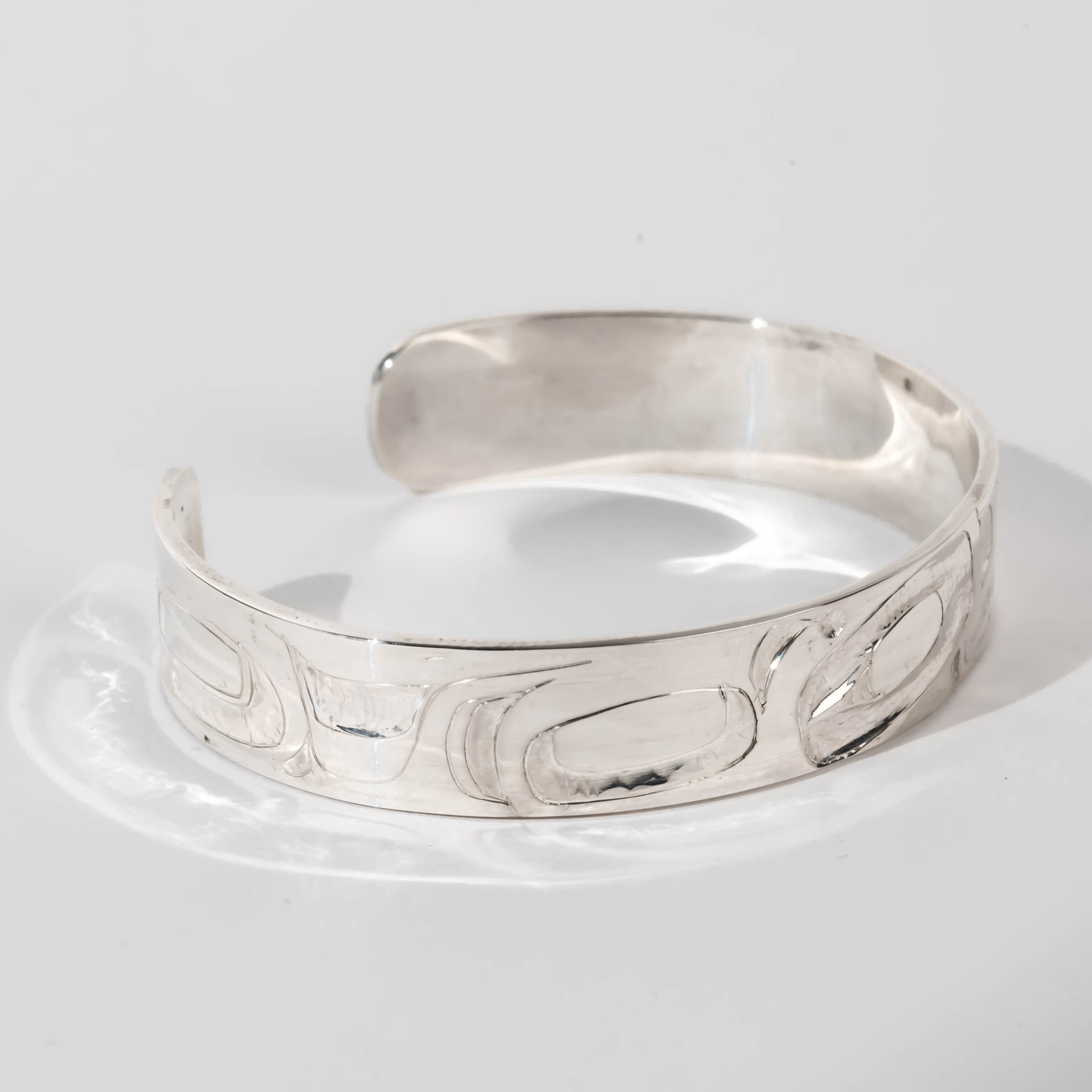 Hand carved sterling silver Orca bracelet by Haida artist Alvin Adkins side view