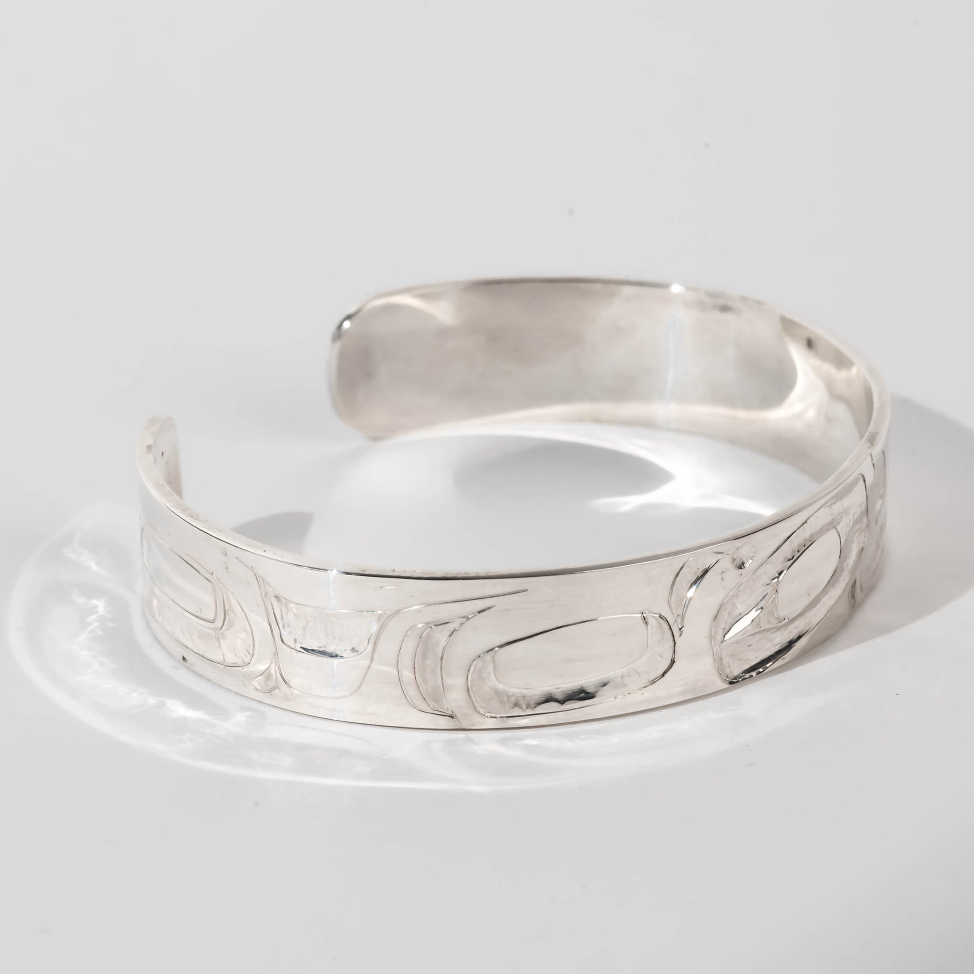 Hand carved sterling silver Orca bracelet by Haida artist Alvin Adkins side view