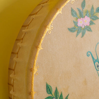 Close up of corner of drum with shiny gold paint and flowers.
