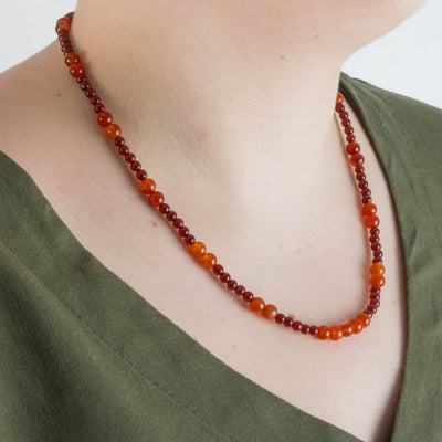 Carnelian necklace worn to the side by a model