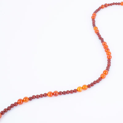 Photo showing of the beads of a Hand beaded deep red and orange Carnelian Agate Necklace with  sterling silver clasp