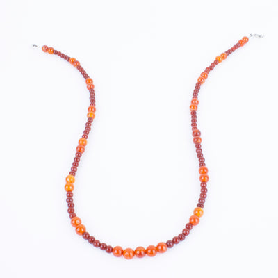 Photo showing of the center beads of a Hand beaded deep red and orange Carnelian Agate Necklace with  sterling silver clasp