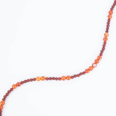 Carnelian Agate Necklace on white background arranged in a wave configuration