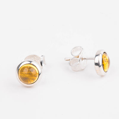 Pair of silver earrings with citrine stones on a white background