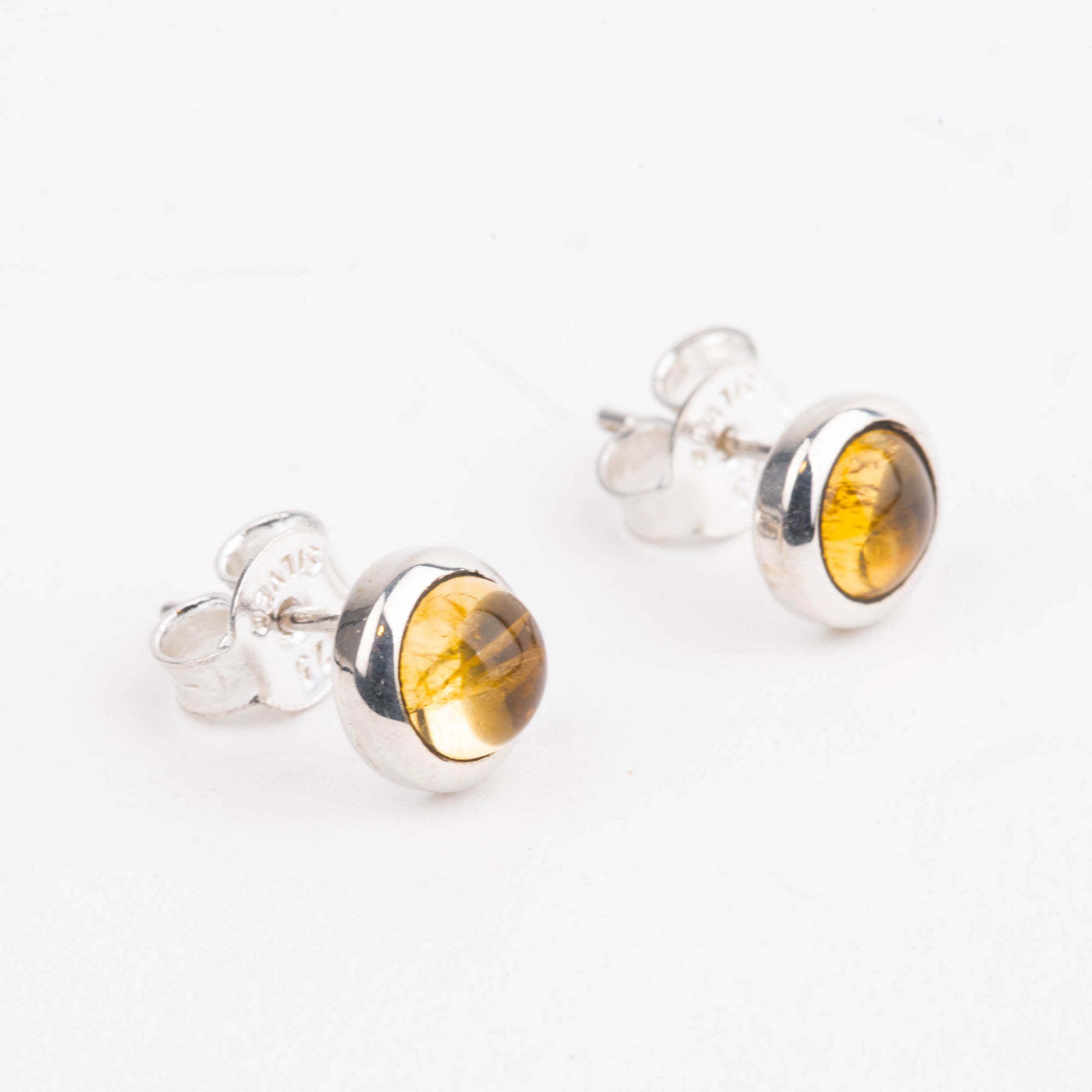 Silver earrings with citrine stones on a white background