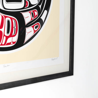 Framed artwork with a red and black abstract design on a beige background