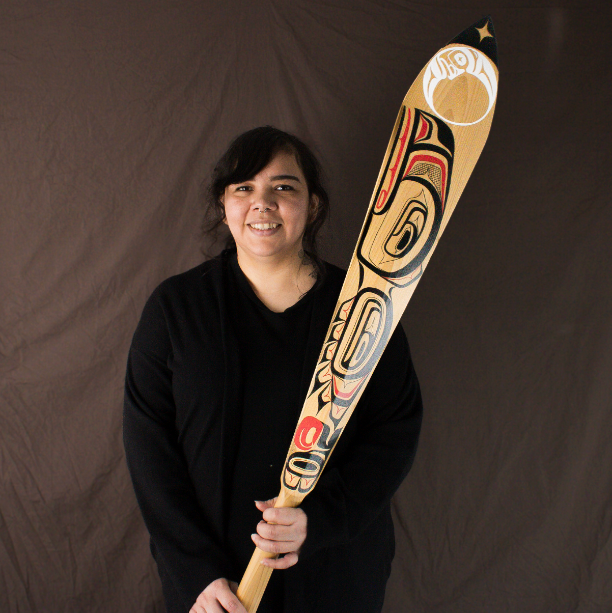 Haida artist Daisy White holding a paddle
