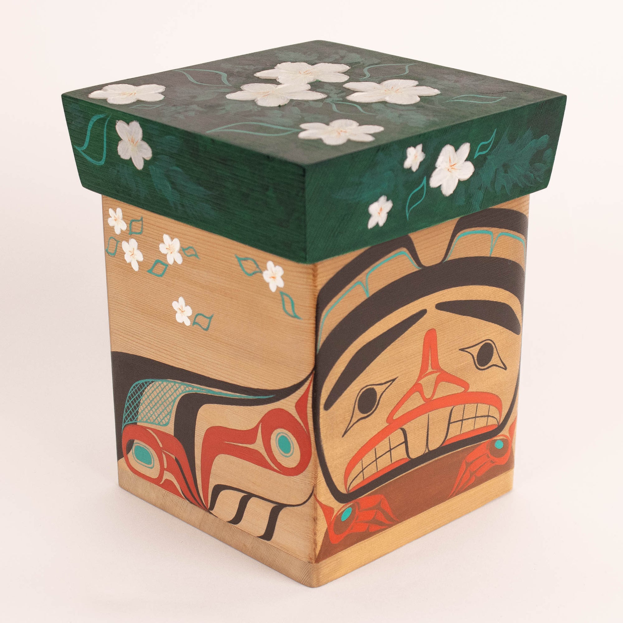 Decorative box with artistic design featuring a face and flowers on a white background