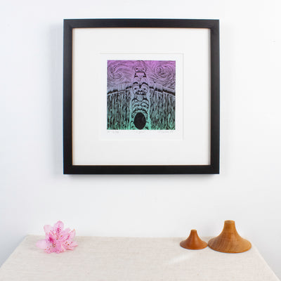 Haida Gwaii fine art print featuring a totem pole in front of a long house, the entrance of the longhouse is at the bottom of the pole with a bear around it, then a beaver and a watchmen. In a modern interrior design set up