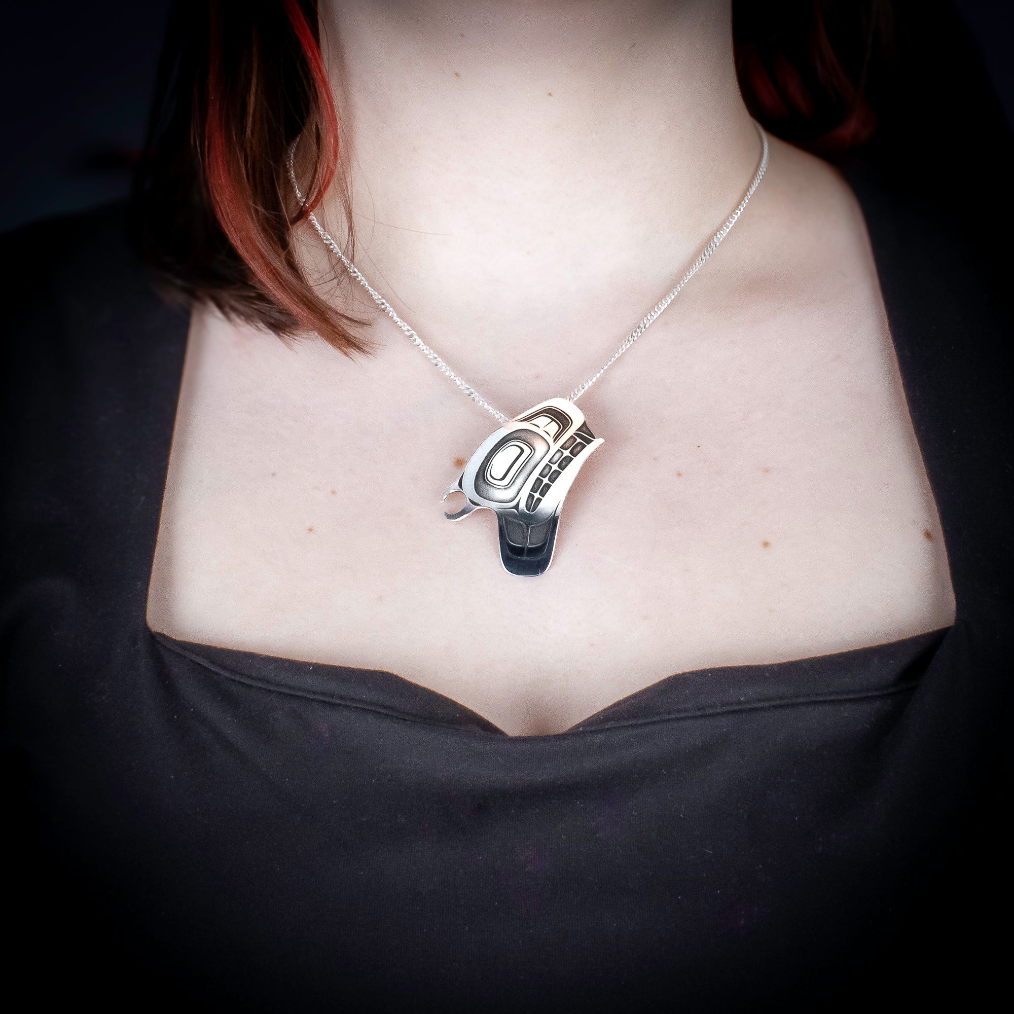 Sterling Silver orca/ Killer whale Pendant by Canadian Handpoke tattoo artist Danika worn by a model