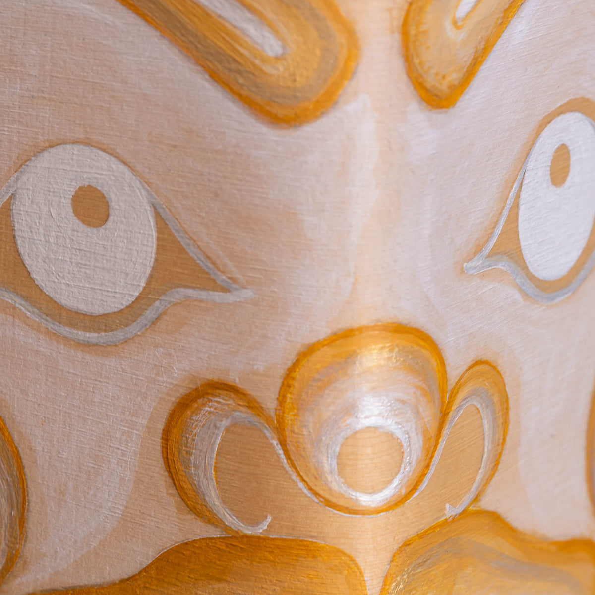 Abstract close-up of artwork with stylized eye-like shapes and flowing organic forms in warm cream, tan, orange, and white tones.