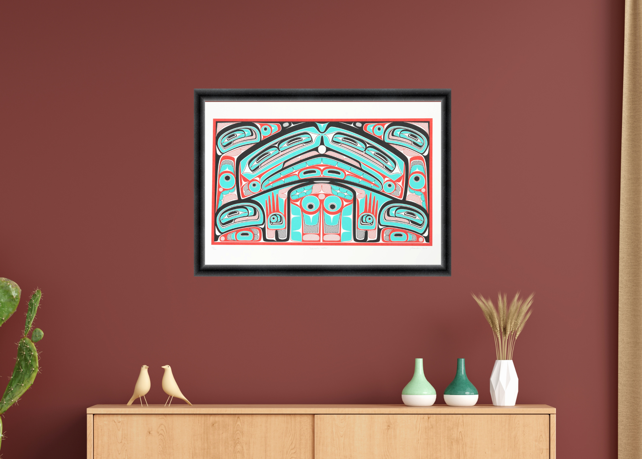 Framed abstract artwork on a red wall above a wooden cabinet with decorative items.