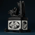 Back corner of a box carved with Haida designs on a dark blue background.