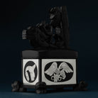 An ornately carved box of black material and sterling silver on a dark blue background.