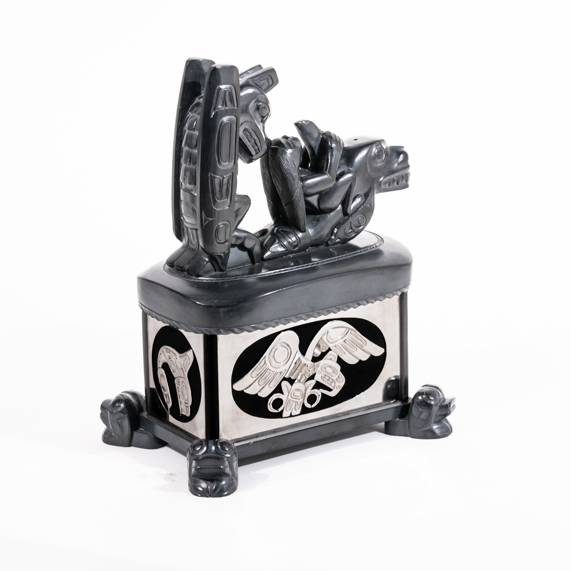 Haida argillite killer whale and thunderbird argillite and sterling silver box done by master Haida artist Ding Hutchingson on a white background showing the back and left side