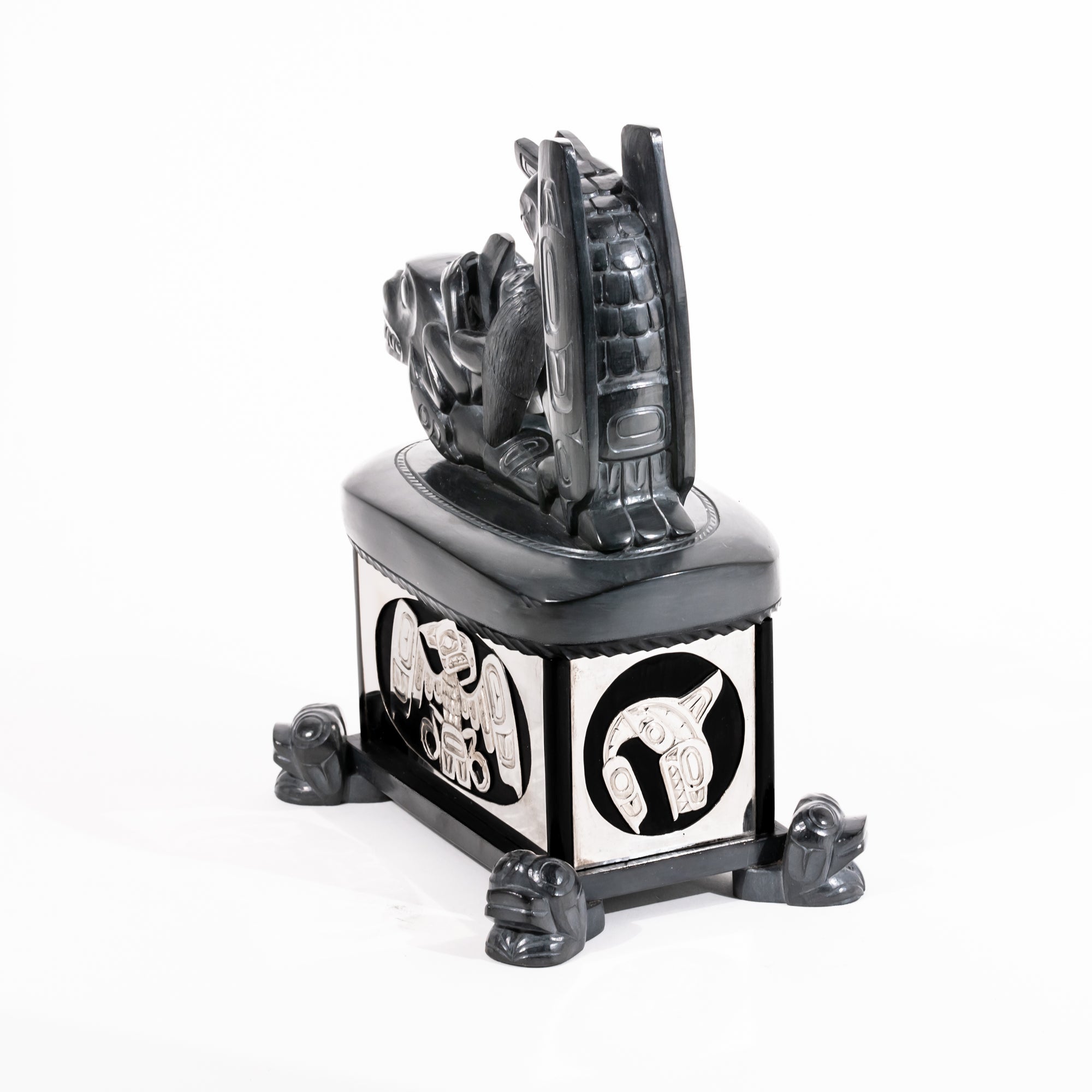 Haida argillite killer whale and thunderbird argillite and sterling silver box done by master Haida artist Ding Hutchingson on a white background showing the back and right side