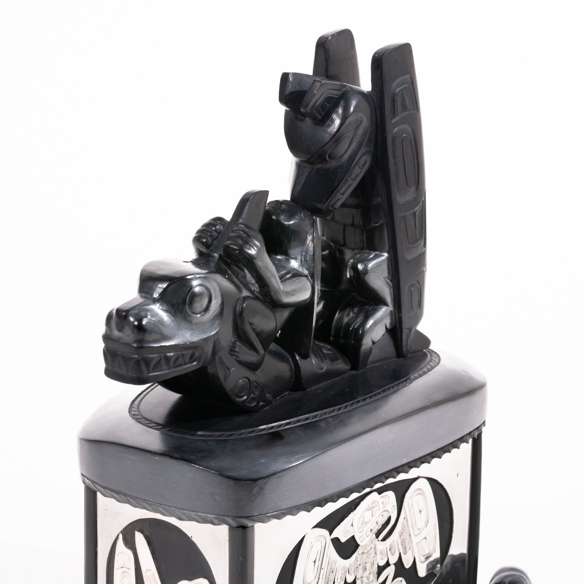 Haida argillite killer whale and thunderbird argillite and sterling silver box done by master Haida artist Ding Hutchingson on a white background showing close up of the top argillite carving