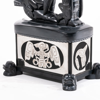 Haida argillite killer whale and thunderbird argillite and sterling silver box done by master Haida artist Ding Hutchingson on a white background showing close up of the silver thunderbird