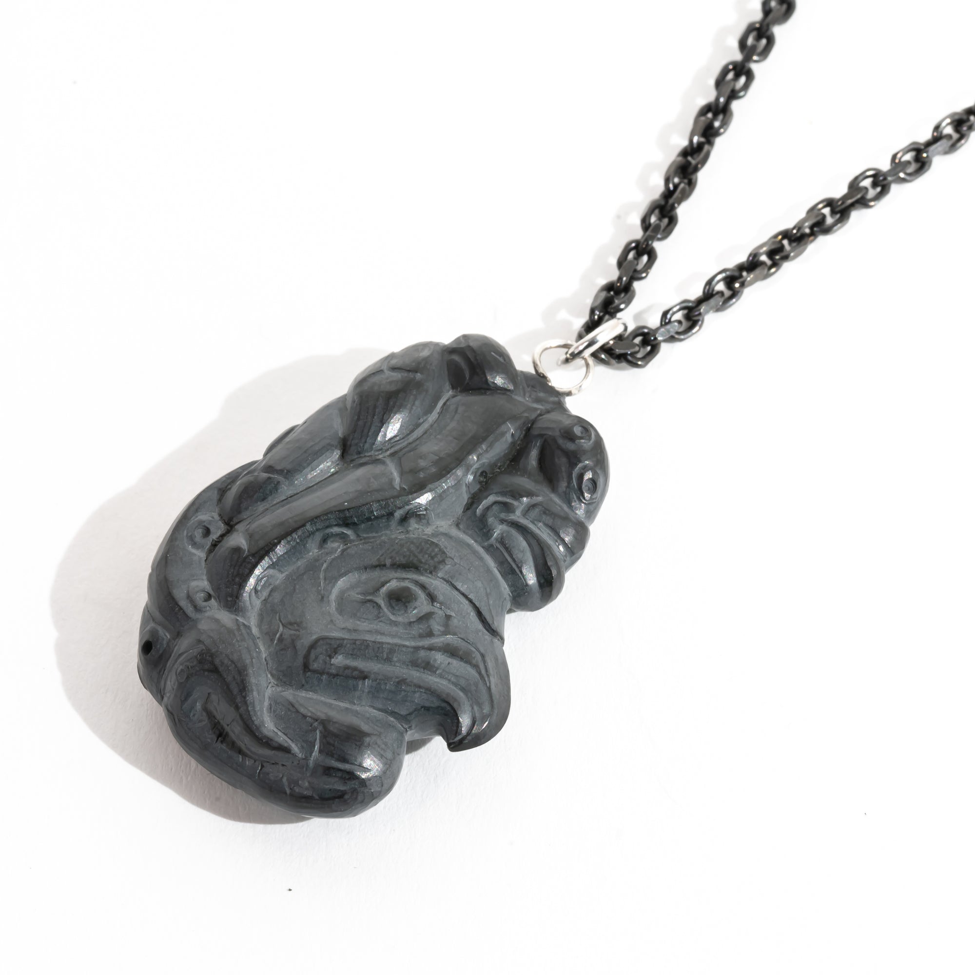 Black Argillite Octopus pendant necklace with intricate Haida Carvings on a white background made by Local Haida Gwaii Artist Melanie Russ