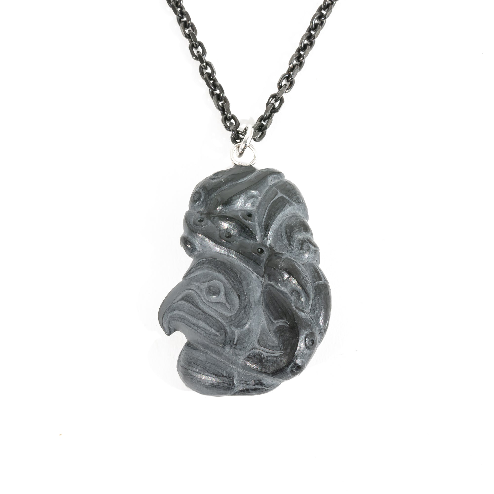 Back side of Black Argillite Octopus pendant necklace with intricate Haida Carvings on a white background made by Local Haida Gwaii Artist Melanie Russ