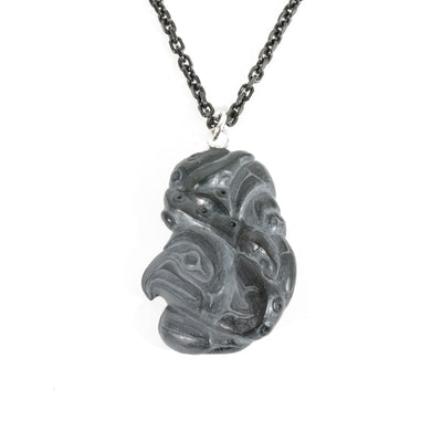 Back side of Black Argillite Octopus pendant necklace with intricate Haida Carvings on a white background made by Local Haida Gwaii Artist Melanie Russ
